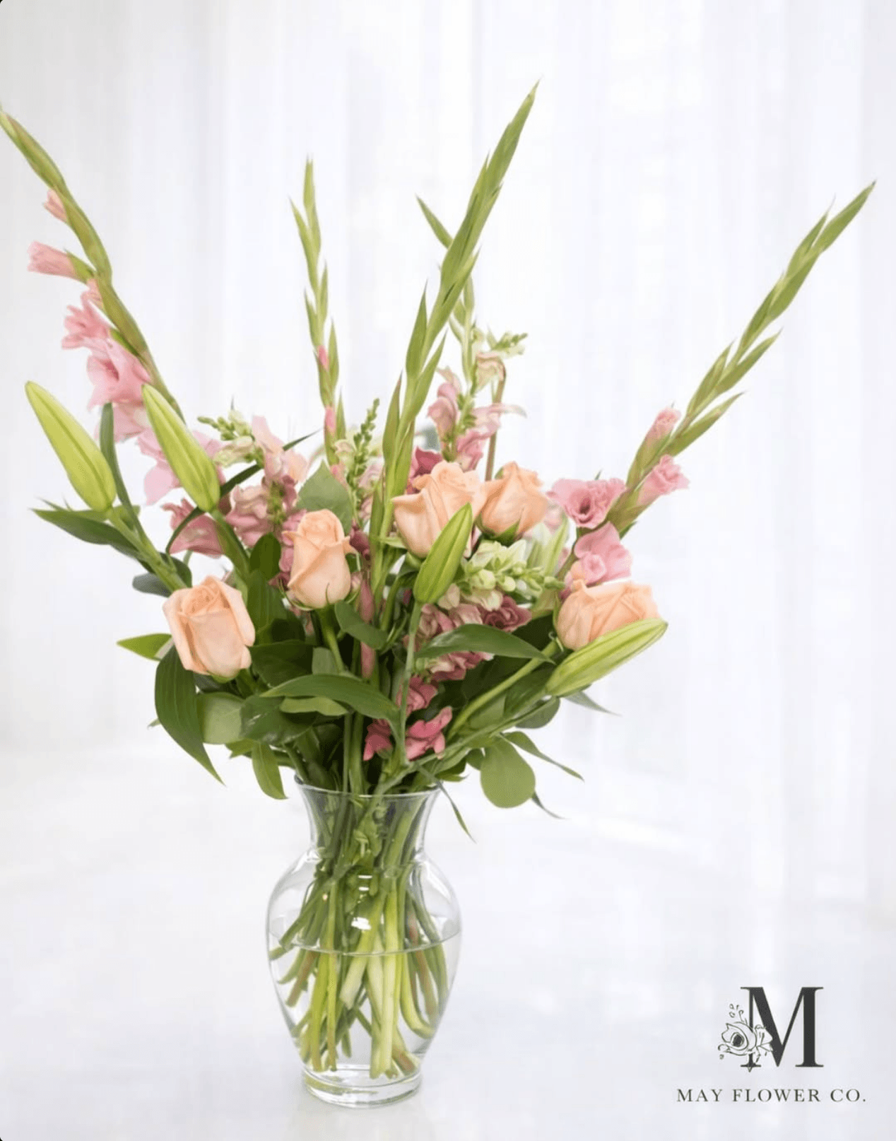 A tall peach-and-cream arrangement composed in the studio.