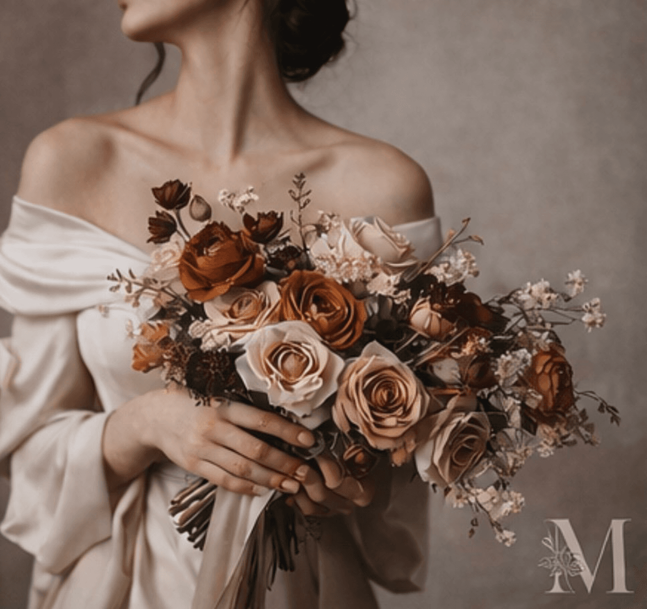 A bride in soft daylight holding a bouquet of copper and cream roses.
